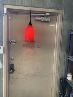 Pendant light 14 inches long 7 inches across the bell shaped bottom, multi colored pattern throughout glass