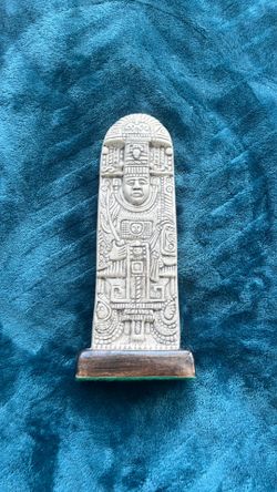 A modern replica of a Mayan stela with intricate relief carvings.