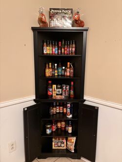 Hot sauce collection in corner black cabinet