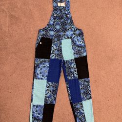 Eye-catching patchwork overalls in mixed blue prints. Adjustable shoulder straps for a customizable fit. Relaxed leg and playful panel details. Bold, 