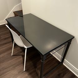 Black work desk with glass topper and white chair