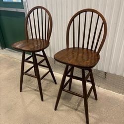 Two solid wood vintage bar stools , both swivel..