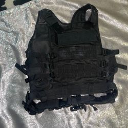 black tactical vest. It is designed for tactical and outdoor use, often seen in activities like airsoft, paintball, hunting, or training.  These vests
