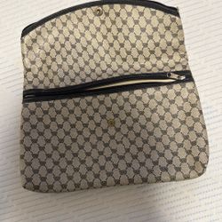  a small, zippered pouch or clutch bag, possibly a cosmetic case. It features a repeating monogram pattern, likely a logo, but the specific brand 