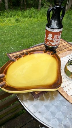 This is a vintage Hull pottery ashtray in a yellow and brown drip glaze finish
