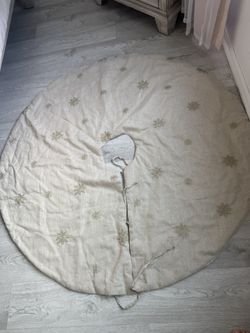 ecorative Christmas tree skirt used to cover the stand at the base of the tree.