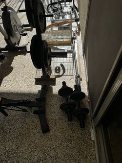 Workout equipment, including stationary bike, elliptical, weights with bench, and inverter.