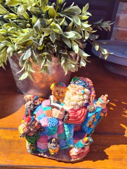 Santa Claus Reading Figurine with Toys by original CRINKLE CLAUS and artificial topiary plants