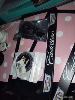 Cadillac licence plates, sunglass clip,  tire caps , cup  holder deco
