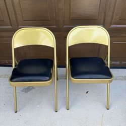 Set of 2 metal folding chairs. Show signs of wear, including scuffs and a tear in the upholstery (see photos). Still functional and sturdy