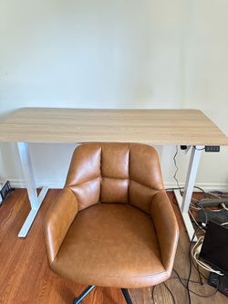 Beige adjustable desk and brown faux leather chair