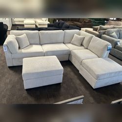 Comfortable beige corduroy reversible sectional sofa with ottoman