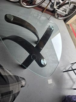 Magnussen Home Allure pie-shaped cocktail table with a glass top and a walnut veneer base in a hazelnut finish. 