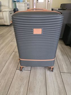 Large IT Luggage 28-inch hardside spinner suitcase in a stylish dark gray with rose gold/copper accents. Features a ribbed exterior design and 4-wheel