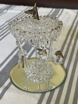 Decorative glass carousel figurine with three unicorns, gold accents, and a mirrored base.