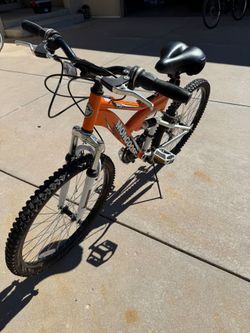 Mongoose XR-75 mountain bike with 24” tires and 21 speed grip shift Shimano. Front and rear shocks and memory foam Bell seat