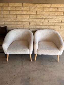 Two (2) white fuzzy chairs