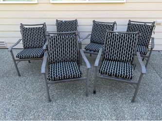 Six dark brown metal patio chairs