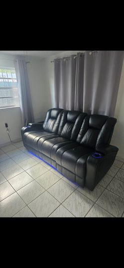 Sofá reclinable de 3 plazas negro con luces y mesa central.