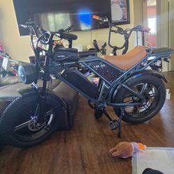 E-BIKE. 5'2 RECOMMENDED HEIGHT.  DARK BLUE AND BLACK FRAME, WITH A TAN LIKE COLORED SEAT