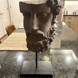 Greek/Roman–inspired stone bust (head) fragment on a stand