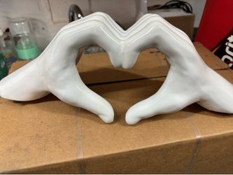 White Ceramic Heart Hands Sculpture  Decorative ceramic sculpture of hands forming a heart shape.
