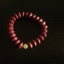 It Is A Bracelet  Purple With A White Pearl