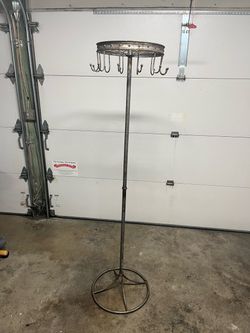 Distressed vintage industrial freestanding coat rack featuring a rotating top bicycle frame hanging hooks and a simple round metal base