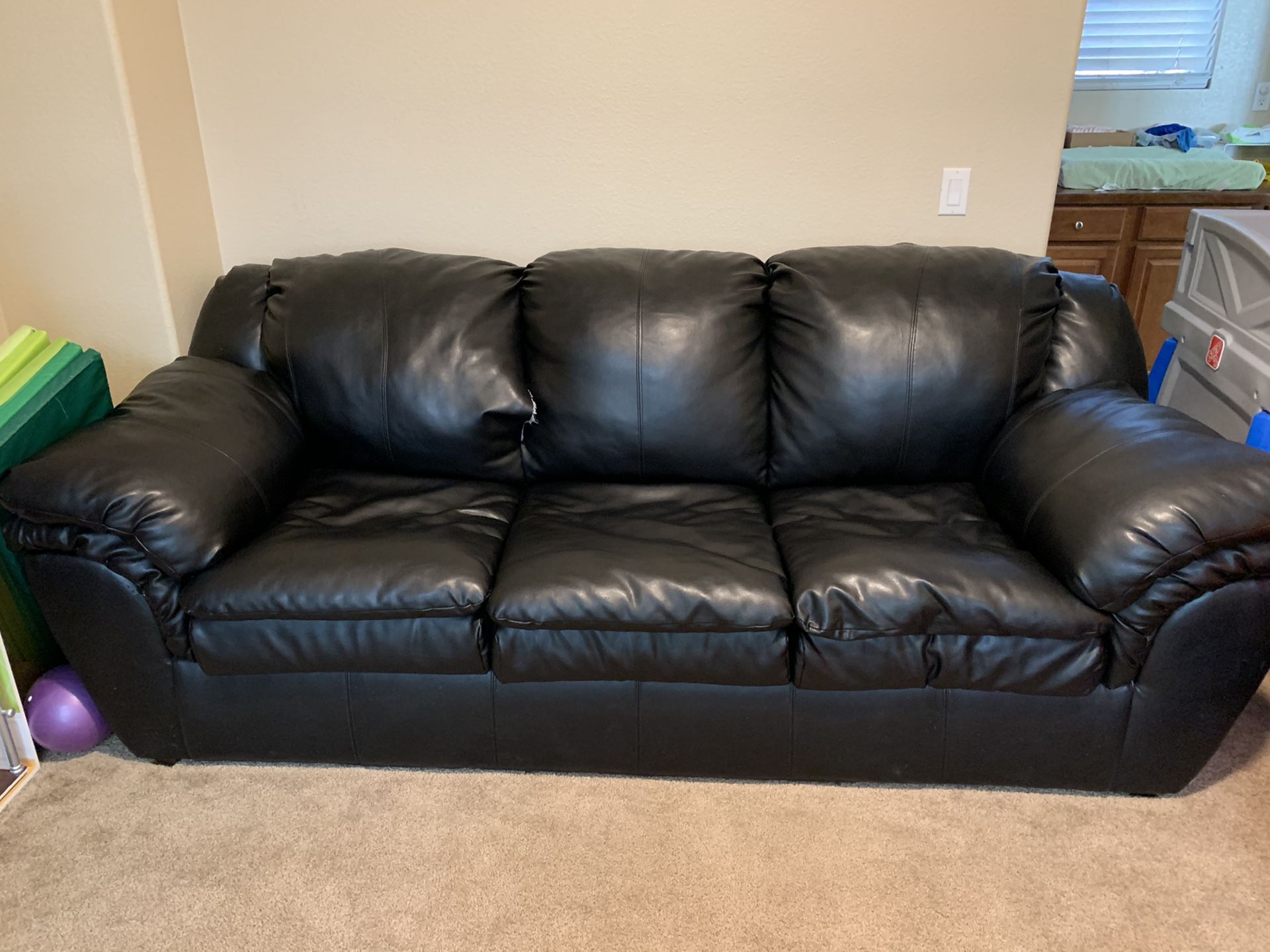 Black pleather couch, average size tear in middle upper cushion otherwise great condition