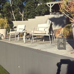 Small outdoor patio loveseat, coffee table, and two chairs