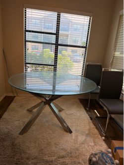 Glass top dining room table with 4 grey chairs