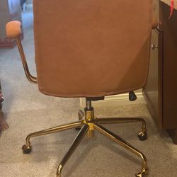 Beautiful burnt orange cushioned office chair with gold wheels
