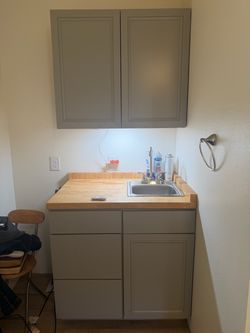 Kitchenette with countertop and sinks and bathroom vanity with sink and toilet mirror and light