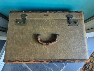 vintage Oshkosh canvas suitcase or travel trunk, typically dating back to the 1930s or 1940s.
This classic piece displays the iconic rectangular, high