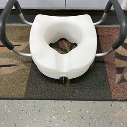 Raised toilet seat with arms
