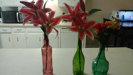 Beautiful wine bottles with a really pretty lilies and the green one is more of a fall