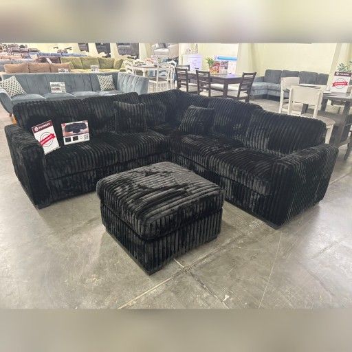 Black jumbo corduroy sectional sofa with ottoman