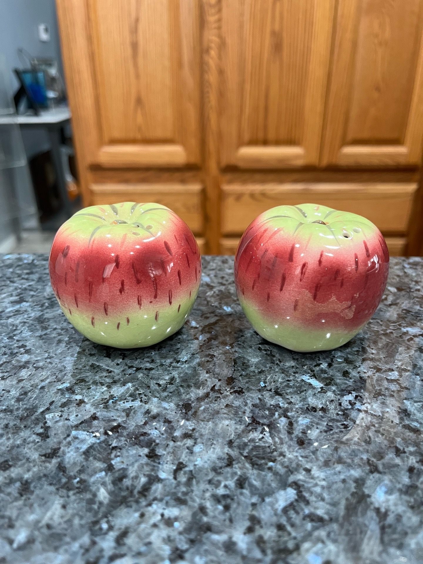 Vintage Ceramic green Red apple salt and pepper shakers. Preowned missing one stopper. On the bottom In pencil is the name of the person who gave i