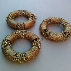 3 Beautiful Gold Wreath Metallic Ornaments - 6” Diameter ($12); 2 Red Hexagon Candle Holders - 3” Wide ($6); 8 Drink Stirrers Pack - 7.5” Long ($5)