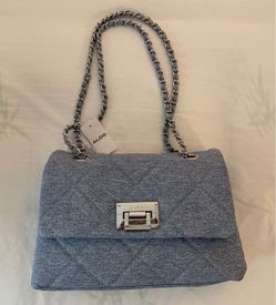 The selected item is an Aldo quilted denim blue shoulder bag featuring a silver-tone chain strap and a prominent lock closure on the front flap