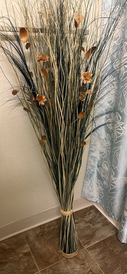 Tall decorative dried grass bundle with flowers