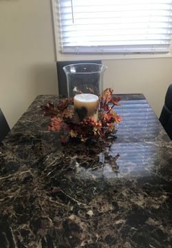 glass vase with fake flowers around it candel not includ