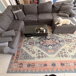 L shaped couch, 2 bar stools, coffee table, and carpet