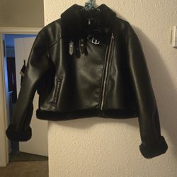 Black faux fur lined leather jacket with belt detail. Size: M