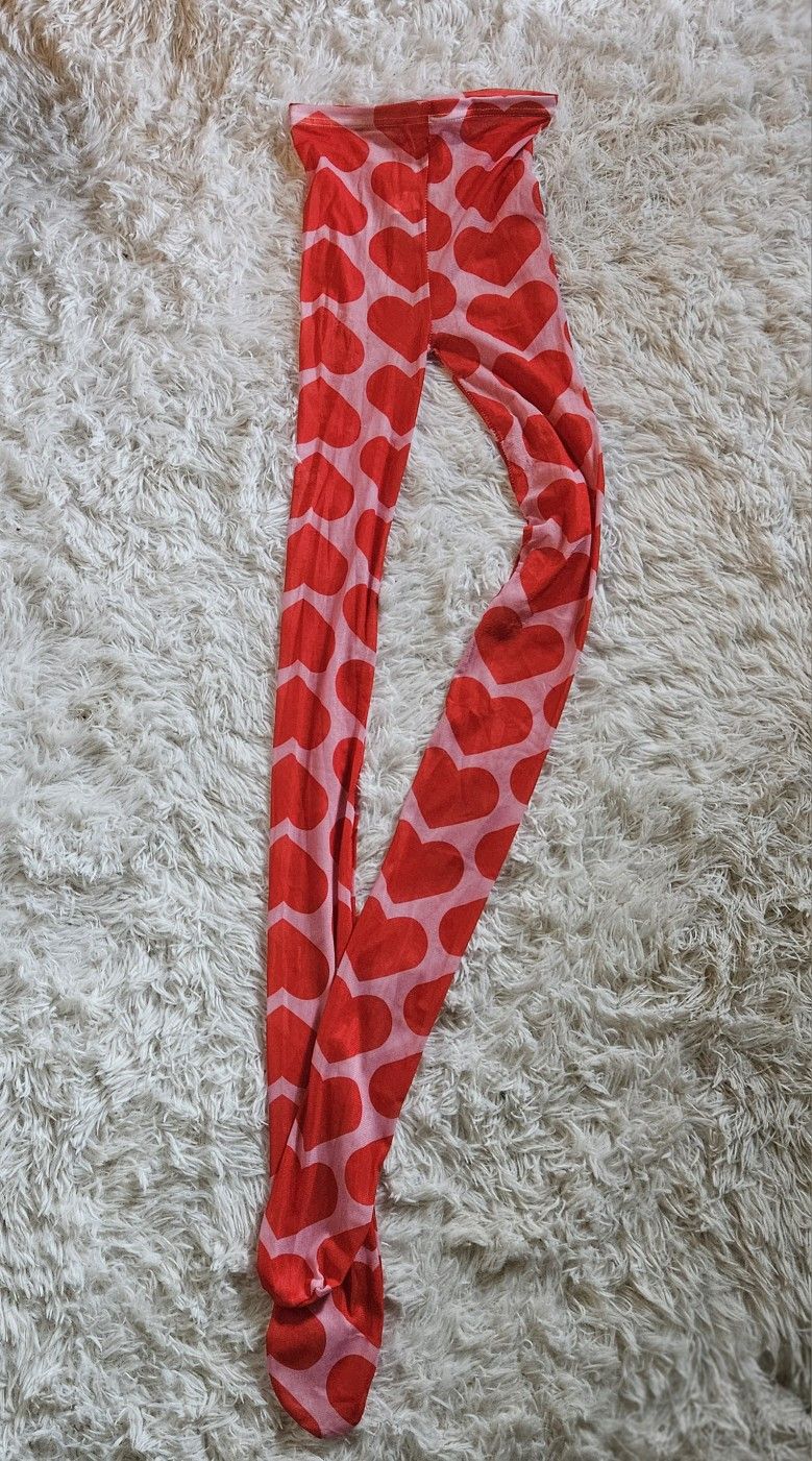Stylish pink tights stockings with a bold heart pattern. Perfect for adding a fun touch to any outfit. Great with a skirt and a pair of boots. one siz