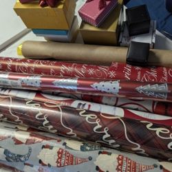 Christmas wrapping paper some new in the roll with plastic others opened. 
A box of bows 
Gift bags, gift boxes and ribbon