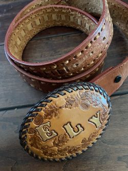 Vintage, personalized hand-tooled leather belt and oval buckle featuring the name "ELY". Floral embossing with stitched border. Size 46.