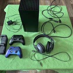 Xbox Series X w/ headset, two controllers, rechargeable battery packs, and a double charging base.