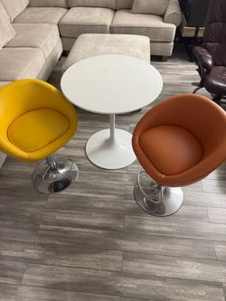 White Tulip Pedestal Table with Yellow and Orange Swivel Chairs