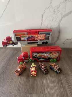 Disney and Pixar Cars toys, primarily featuring Mack haulers and Mater vehicles.